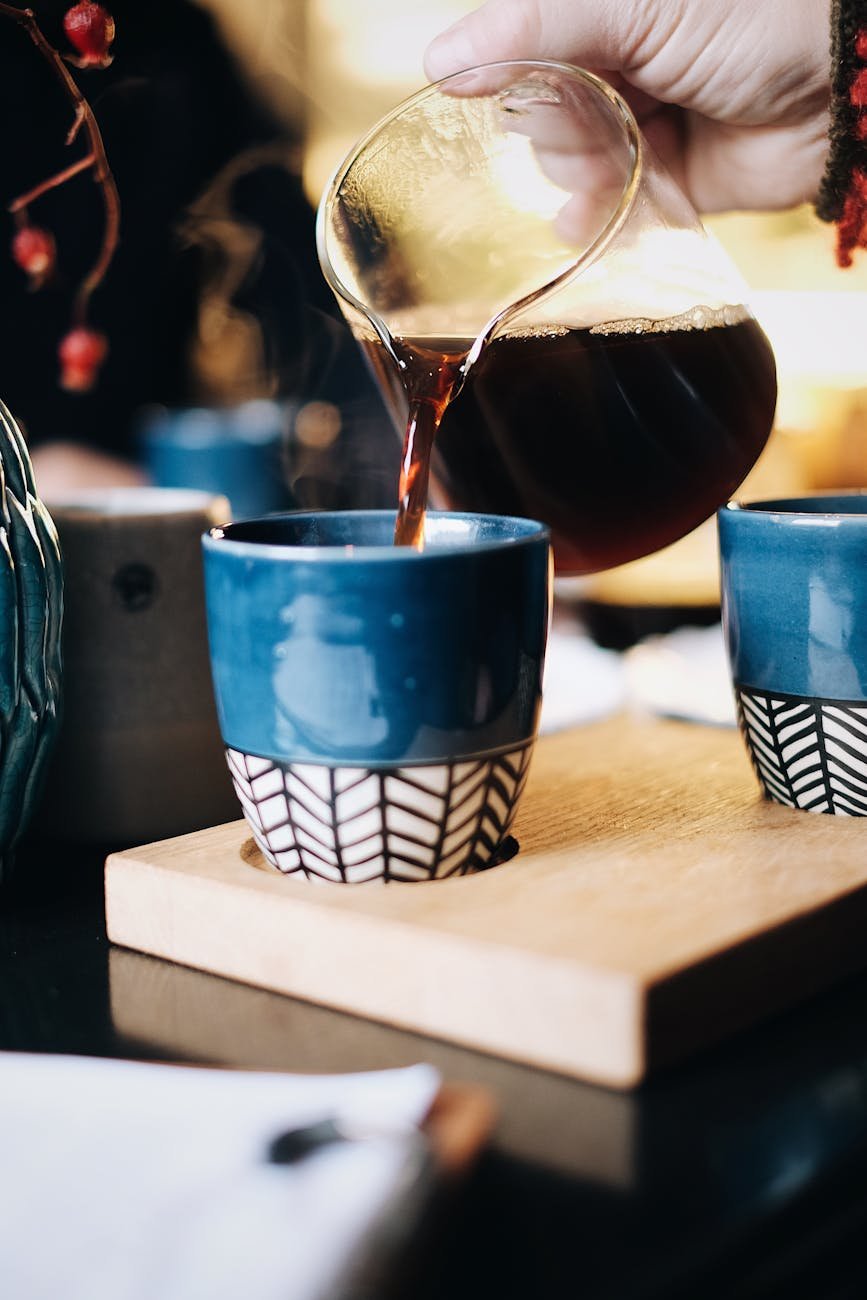 person pouring tea on cup